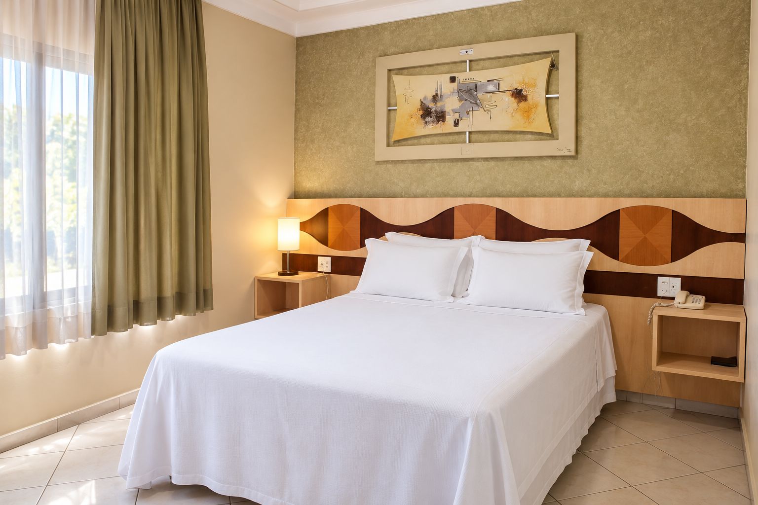 A hotel room with a bed, bedside tables, a lamp, a painting, and a window with curtains.
