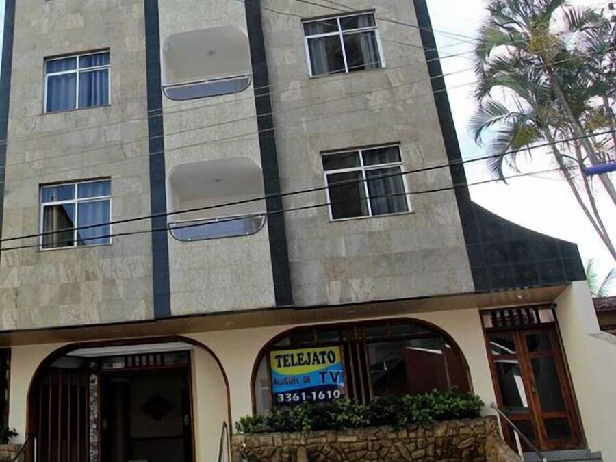 Un edifici amb un rètol de servei de televisió, una entrada ben visible i una construcció veïna.