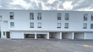 A modern building with multiple garage-style parking spaces and a flat roof. - Auto-hotel Mediterraneo (Banderilla)