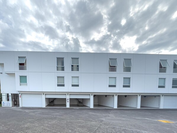 A modern building with multiple garage-style parking spaces and a flat roof. - Auto-hotel Mediterraneo (Banderilla)