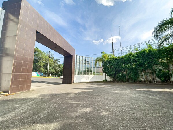 Une entrée moderne, caractérisée par une grande arche et une façade en verre.