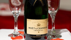 A bottle of Moët & Chandon Imperial Brut champagne with two empty wine glasses on a table. - Auto-hotel Mediterraneo (Banderilla)