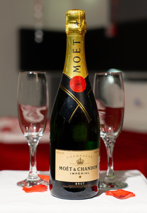 A bottle of Moët & Chandon Imperial Brut champagne with two empty wine glasses on a table. - Auto-hotel Mediterraneo (Banderilla)