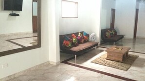 A living room with a sofa, a wooden coffee table, and a television mounted on the wall. - Hotel Porton Colonial (Medellín)