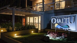 A modern building with a sign reading "Hostería CHALTU".