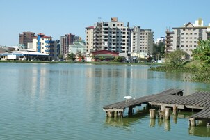 Vista al agua con un muelle y edificios al fondo.