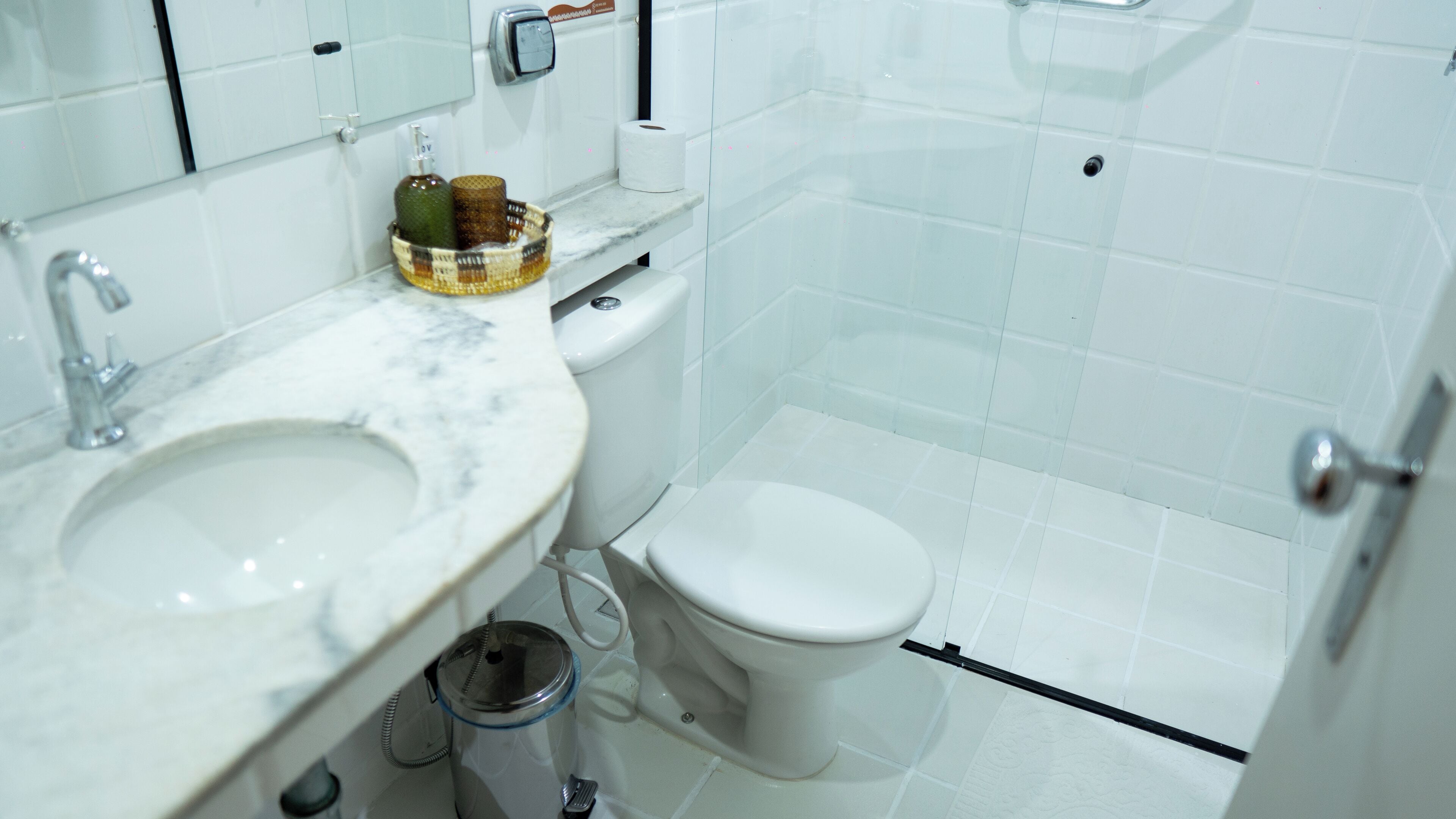 Een badkamer met een wit wastafel, toilet en douche.