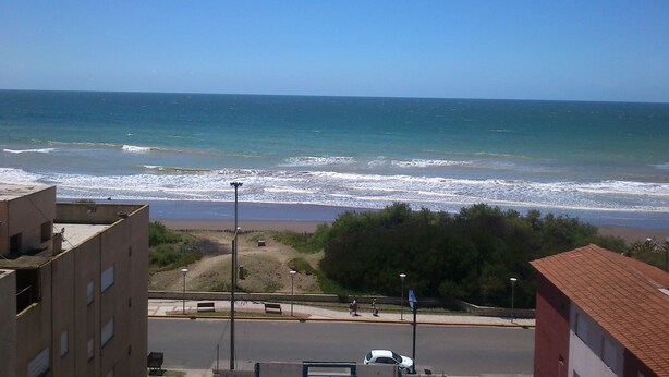 A coastal view with a beach, a road, and buildings. - Hotel La Argentina (San Bernardo del Tuyú)
