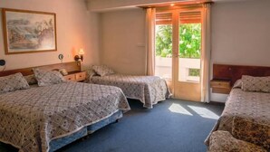 A hotel room with two beds, a painting on the wall, a lamp, and a window with curtains. - Hotel Crismalu (San Martín de los Andes)