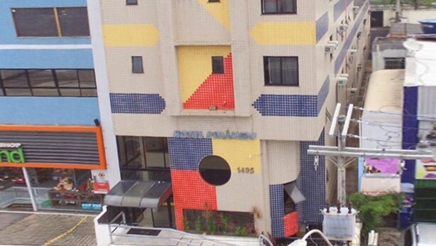 Ein mehrgeschossiges Hotel mit einer markanten, geometrischen Fassade, verziert mit einem Mix aus roten, blauen und gelben Mustern.