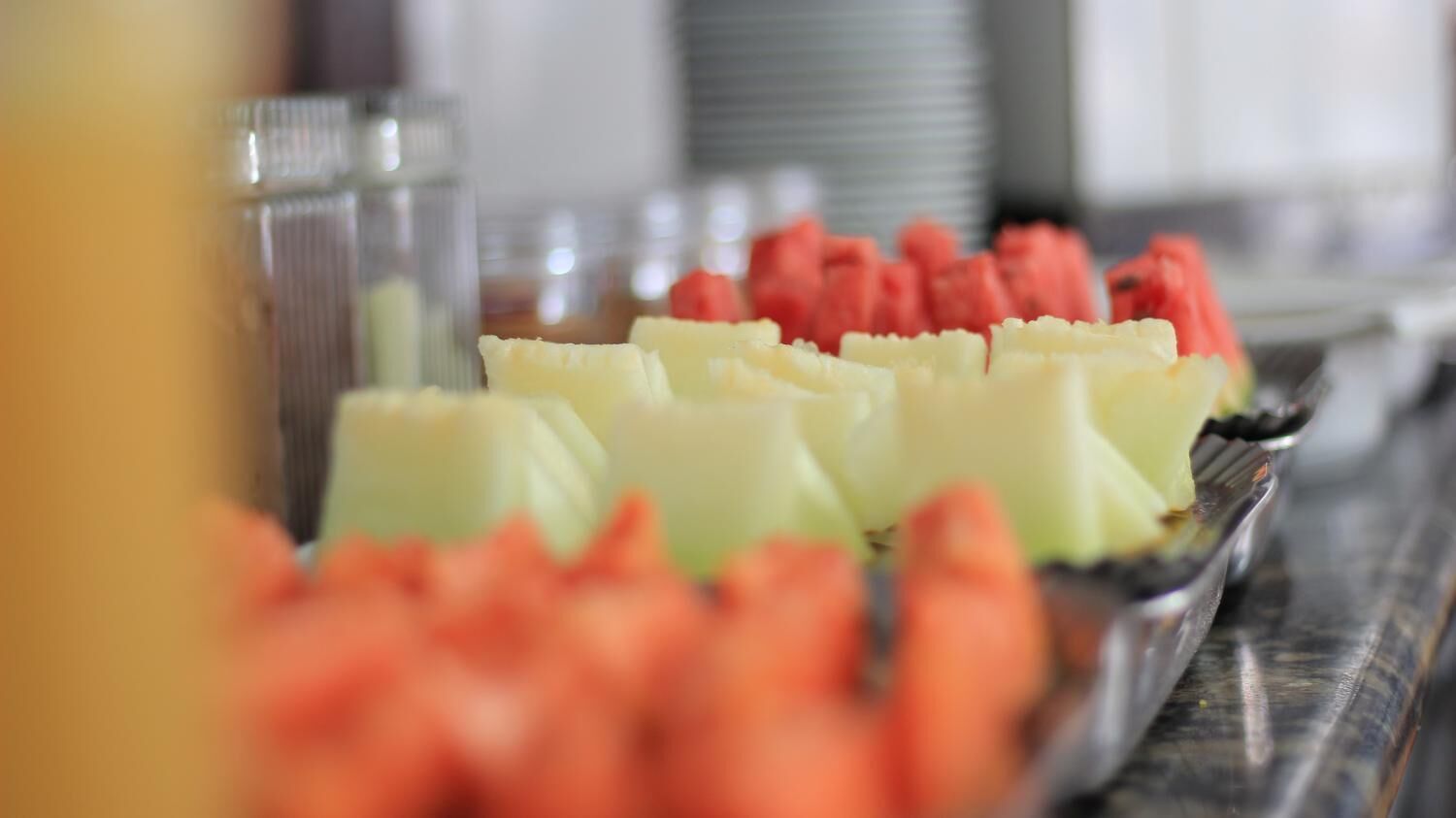 A buffet table with various fruits including watermelon and pineapple.