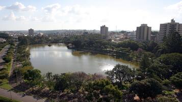 Un lago circondato da alberi e edifici, con una strada che costeggia la riva.