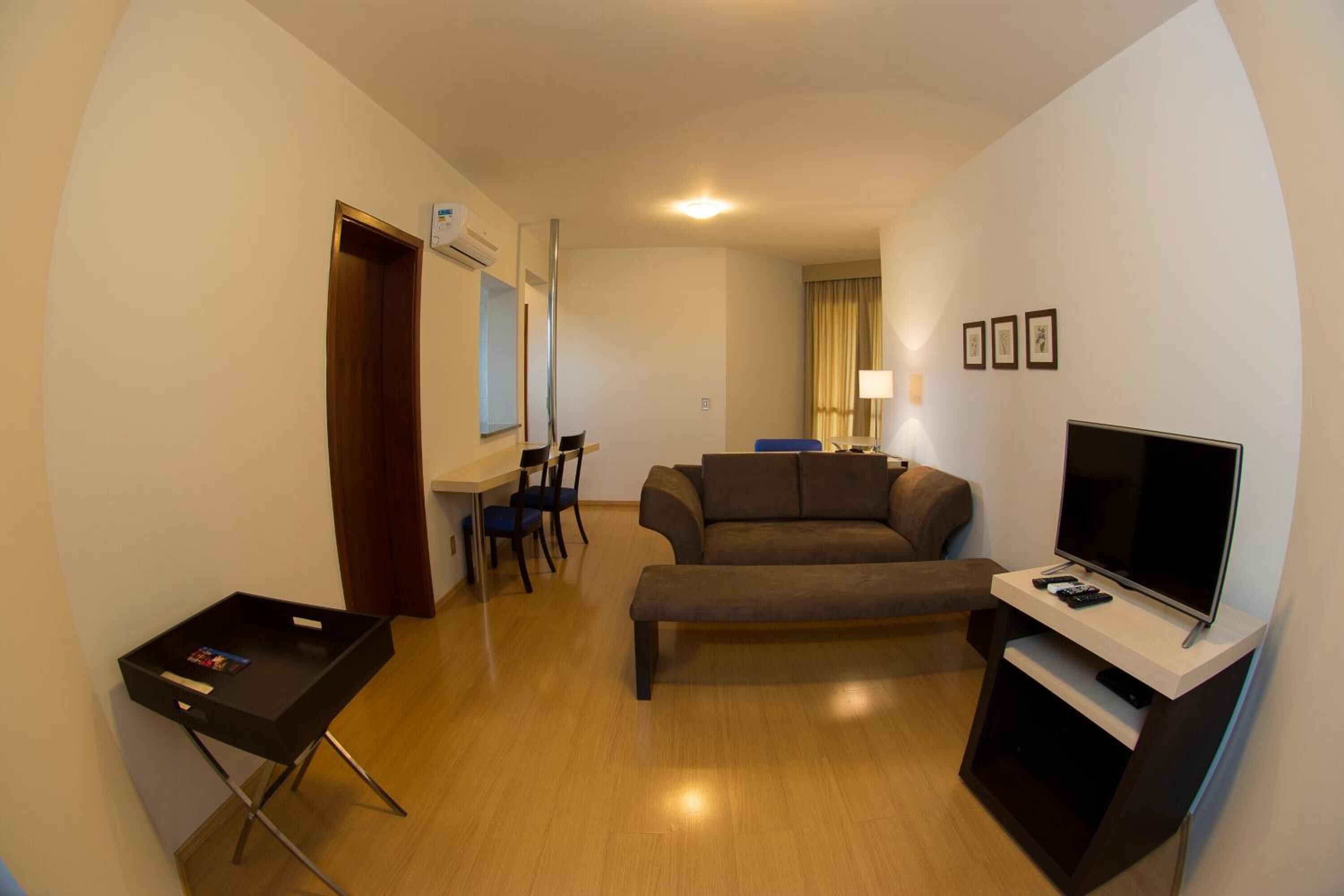 A compact living space with a sofa, a TV, a small table, and a chair.