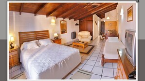 Un dormitorio amplio con una cama grande, techo de madera y televisor.