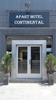 Fachada del Apart Hotel Continental, con un amplio acceso por una puerta de vidrio, puertas numeradas 1288 y 1290, y dos plantas en macetas a cada lado.