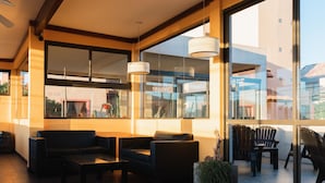 A modern interior with large windows, leather sofas, and a coffee table. - Complejo Playa Norte (Mar de Ajo)