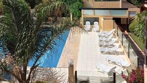 A modern hotel with a pool, lounge chairs, and a view of the sea. - Complejo Playa Norte (Mar de Ajo)