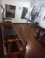 Un gimnasio con equipo de ejercicio, un espejo y suelo de madera.