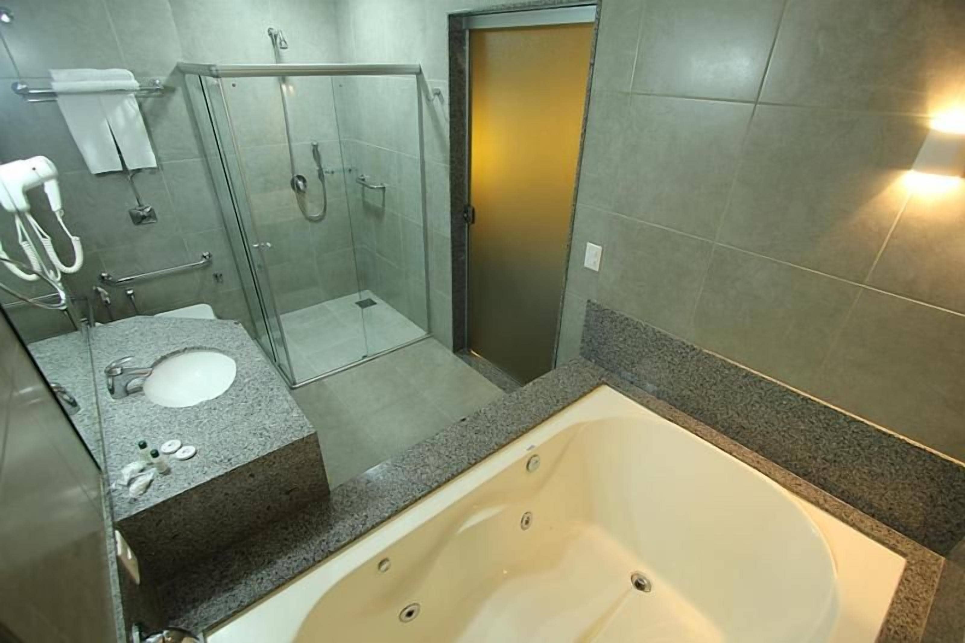 A bathroom with a bathtub, shower, and sink.
