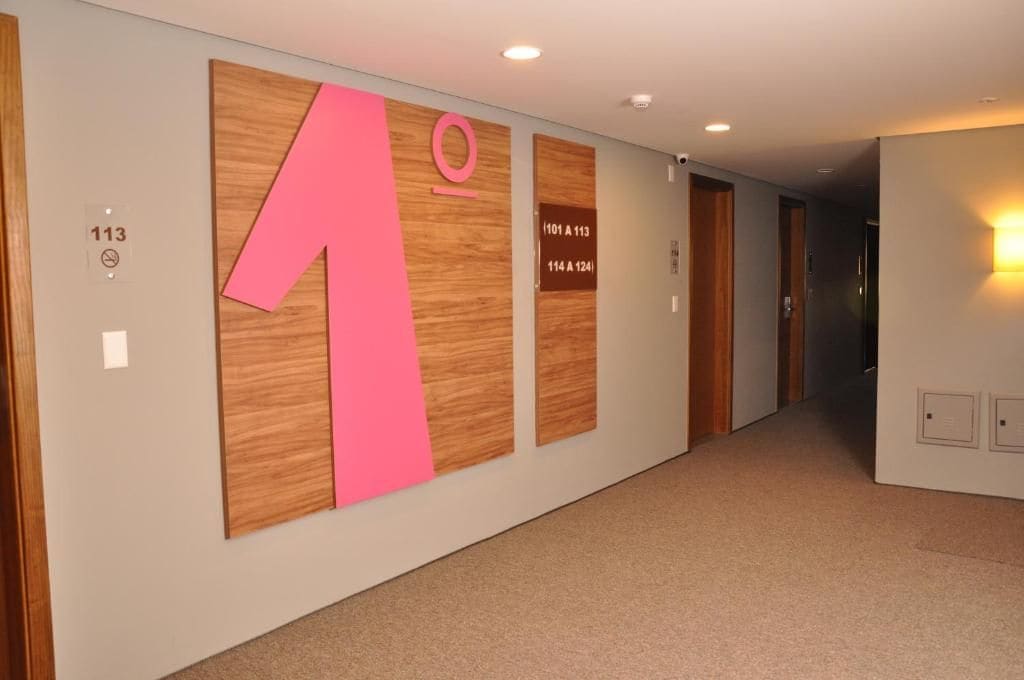 A hallway with wooden paneling and large numbers indicating room numbers.