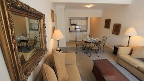 A living room with a sofa, a coffee table, and a dining area with a table and chairs. There is a kitchen in the background. - Suites Newton (Mexico City)