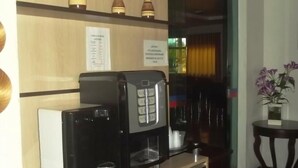 Una máquina de café y un panel con la carta en el vestíbulo de un hotel.