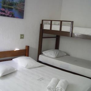 A bunk bed room with a wooden headboard, white bedding, and a painting of a landscape on the wall.