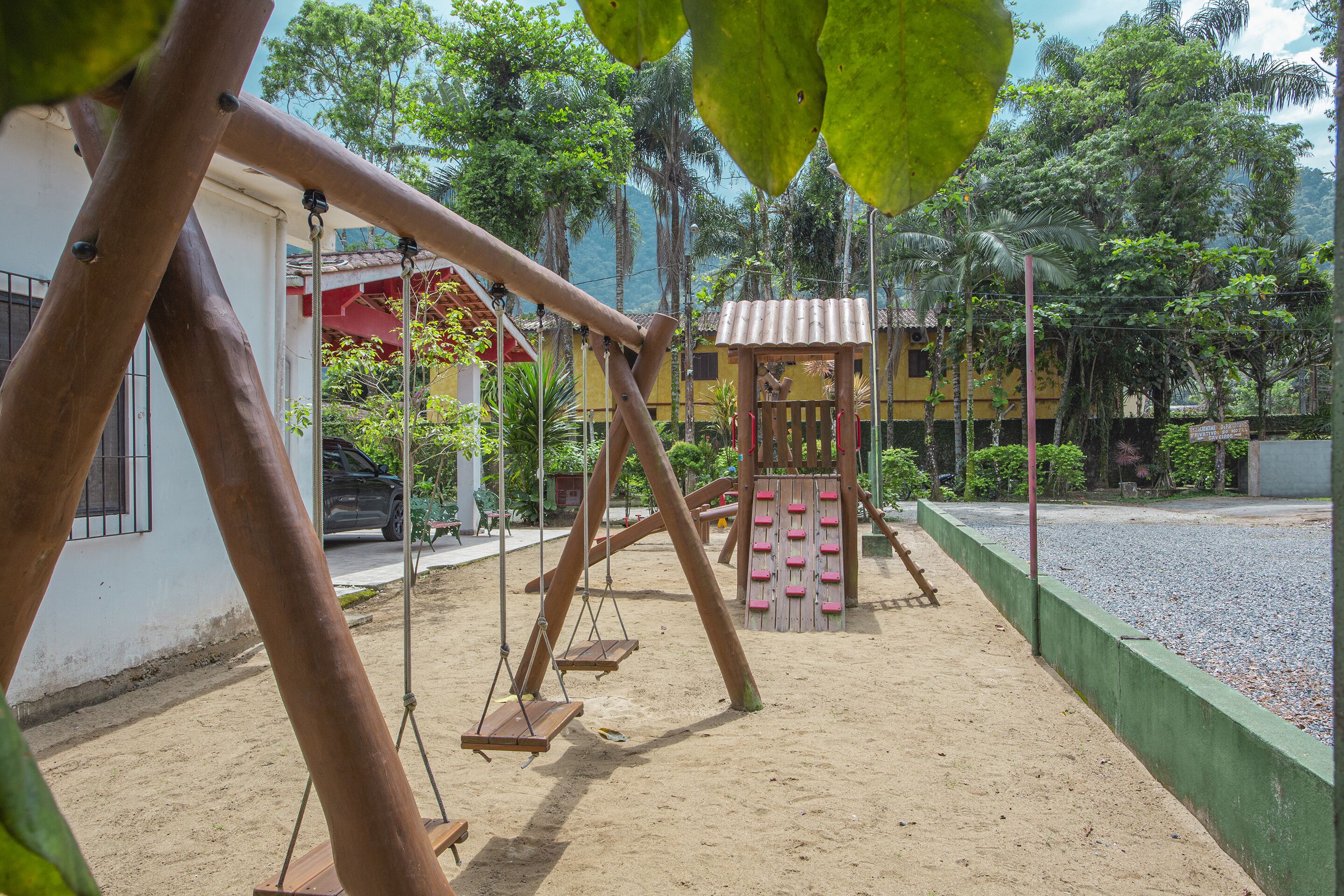A playground with swings and a climbing structure.