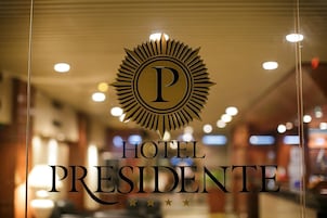 Un letrero de hotel con un llamativo logotipo 'P' y el nombre 'HOTEL PRESIDENTE'.