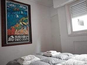 A bedroom with a bed, a window with blinds, and a poster on the wall. - Alma Viva (Mar del Plata)
