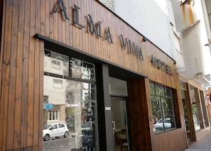 A hotel named "ALMA VIVA HOTEL" with a wooden facade and large windows. - Alma Viva (Mar del Plata)