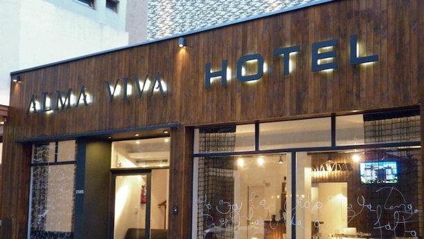 A hotel named "ALMA VIVA HOTEL" with a wooden facade and large windows. - Alma Viva (Mar del Plata)
