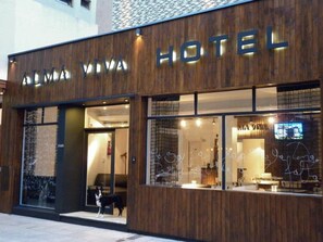 A hotel named "ALMA VIVA HOTEL" with a wooden facade and large windows. - Alma Viva (Mar del Plata)