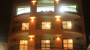 A multi-story building with balconies and windows, featuring a central light fixture and a series of windows on each floor. - AltoParque Hotel (Salta)