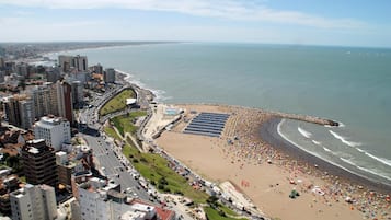 Un paisaje urbano costero con una playa, edificios altos y cielo despejado.