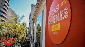 Een hotelschild met de naam 'CASI GUEMES HOTEL' en de tekst 'LOW COST' eronder.