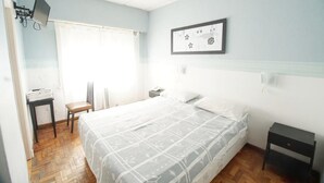 A bedroom with a bed, a desk, a chair, and a framed picture on the wall. - Hotel Sousas (Mar del Plata)