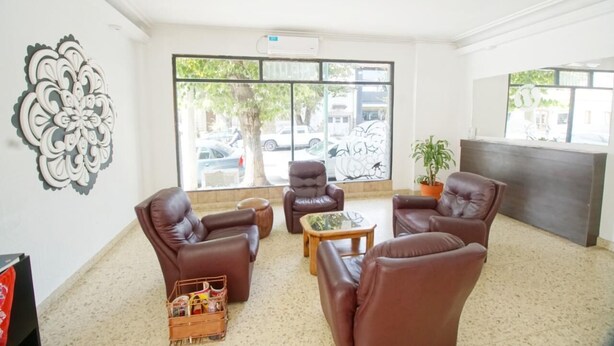 A lobby with leather sofas, a coffee table, and a reception desk. - Hotel Sousas (Mar del Plata)