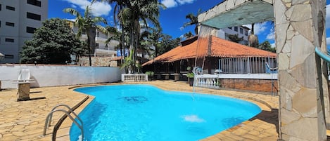 Una piscina al aire libre, tumbonas