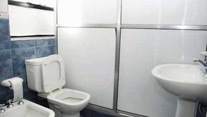 Un baño con inodoro, bidé y lavamanos.