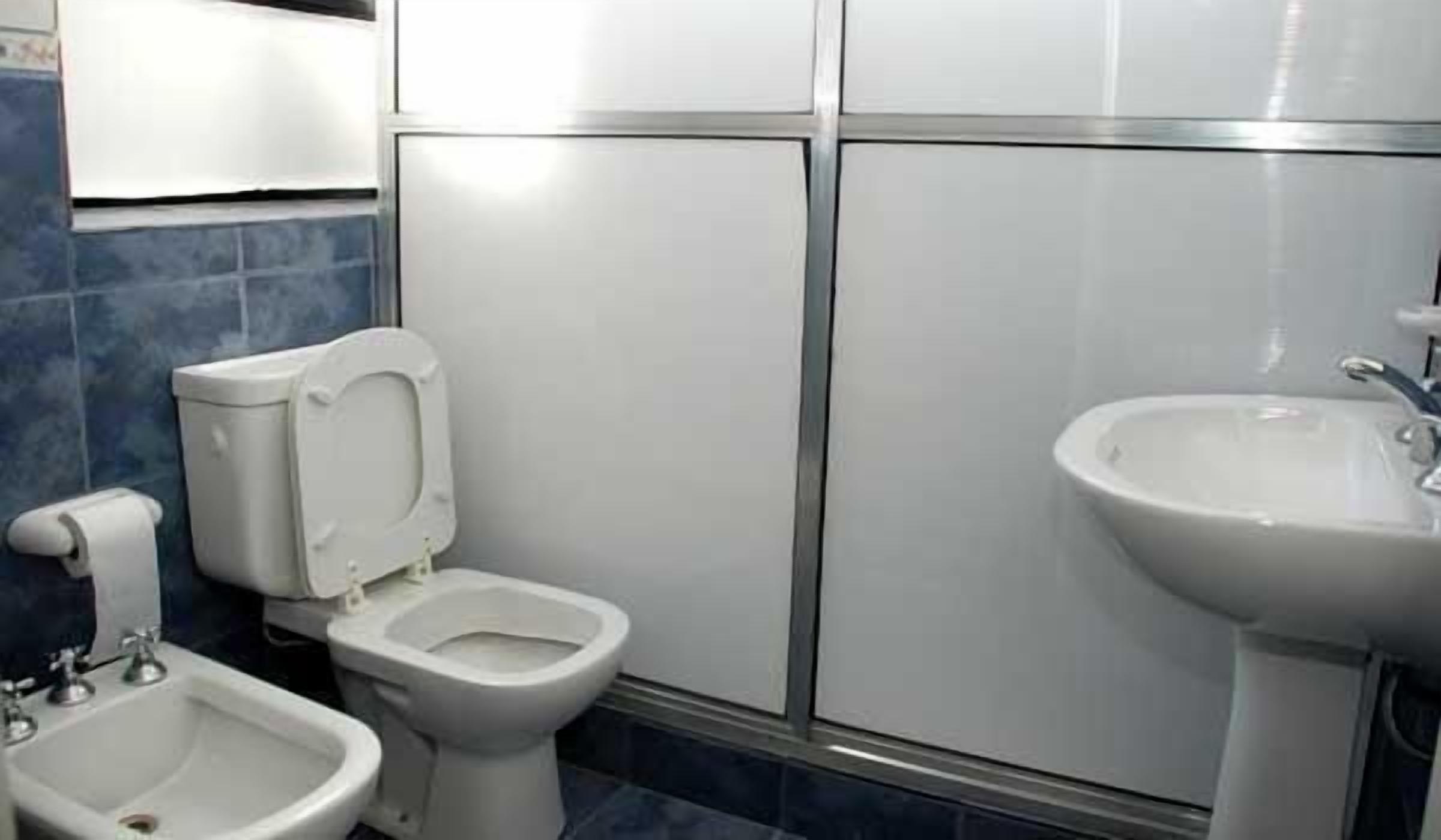 Un baño con inodoro, bidé y lavamanos.