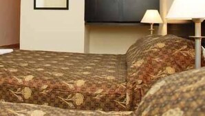 Una habitación con cama, armario, espejo y lámpara.