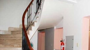 Una escalera con barandilla de madera y un extintor rojo sobre una encimera.