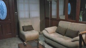 A living room with a sofa, armchair, and a coffee table. - El Fundador Apartamento (Quito)