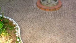 A courtyard with a central fountain, a staircase, and a door. - El Fundador Apartamento (Quito)