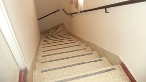 A staircase with a handrail and a window with curtains. - Mar del Faro (Mar del Plata)