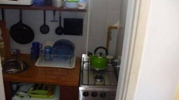 Una cocina compacta equipada con microondas, hervidor y cocina.