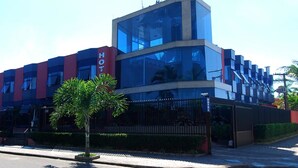 Un hotel moderno con una fachada de vidrio destacada, una paleta de colores rojo y azul, y un cartel que indica que es un hotel.