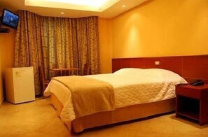 A hotel room with a bed, a television on the wall, and a small table. - Hotel Santamaria (Guarujá)