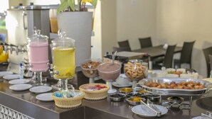 A buffet setup with various food items and beverages. - Pontal Praia Hotel (Porto Seguro)